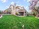 Spacious backyard featuring lush green grass, mature trees, and a tiered deck at 62 N Ranch Rd, Littleton, CO 80127
