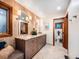 Stylish bathroom featuring a double vanity with granite counters, patterned wallpaper, and updated fixtures at 62 N Ranch Rd, Littleton, CO 80127