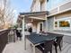 A covered outdoor deck with a dining table with views of the backyard and outdoor seating area at 62 N Ranch Rd, Littleton, CO 80127