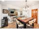 Open dining room with modern light fixture, views of the living room, and wooden door at 62 N Ranch Rd, Littleton, CO 80127