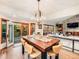 Elegant dining area with wood table, designer lighting, and open access to the deck and living room at 62 N Ranch Rd, Littleton, CO 80127