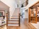 Grand entryway with wood floors, a staircase with white railings, and a view into other living spaces at 62 N Ranch Rd, Littleton, CO 80127