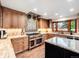 Modern kitchen showcasing wood cabinets, granite countertops, stainless steel appliances, and a center island at 62 N Ranch Rd, Littleton, CO 80127