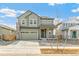 Charming two-story home with a two car garage, a stone chimney, and beautiful landscaping at 9293 Biscay St, Commerce City, CO 80022