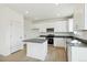 Bright kitchen features white cabinets, stainless steel appliances, grey counters, and wood-look flooring at 9293 Biscay St, Commerce City, CO 80022