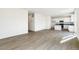 Bright and airy living room featuring wood-look floors and neutral walls, flowing into kitchen at 9293 Biscay St, Commerce City, CO 80022