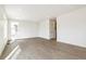 Expansive living room with neutral walls, wood-look floors, and plenty of natural light from the large window at 9293 Biscay St, Commerce City, CO 80022