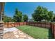 Spacious backyard featuring an artificial lawn, stone walkway and modern horizontal wood fence at 915 N Kearney St, Denver, CO 80220
