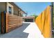 Wide driveway leading to a garage and fenced yard with a modern horizontal wood gate at 915 N Kearney St, Denver, CO 80220