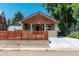 Inviting craftsman bungalow featuring a shingle roof, rock accents, and a modern horizontal wood fence at 915 N Kearney St, Denver, CO 80220