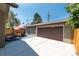Exterior rear view of a detached garage, outdoor patio set, and lush backyard landscaping at 915 N Kearney St, Denver, CO 80220
