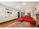 Bright living room with hardwood floors, stone fireplace, red couch, and decorative artwork at 915 N Kearney St, Denver, CO 80220