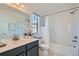 Bright bathroom with a large mirror, white tile shower, and sleek vanity at 15252 W 69Th Pl, Arvada, CO 80007