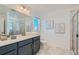 Modern bathroom with dual vanities, a glass-enclosed shower, and neutral finishes at 15252 W 69Th Pl, Arvada, CO 80007