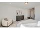 Well-lit bedroom featuring a gray dresser, modern decor, and a cozy accent chair at 15252 W 69Th Pl, Arvada, CO 80007