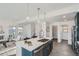 Open-concept kitchen featuring an island, stainless steel appliances, and modern lighting at 15252 W 69Th Pl, Arvada, CO 80007