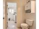 Bright bathroom with a toilet, modern wall cabinet and a doorway leading to the laundry room at 805 Northridge Rd, Highlands Ranch, CO 80126