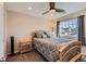 Cozy bedroom featuring a stylish bed, ceiling fan, nightstand, and a window with neighborhood views at 805 Northridge Rd, Highlands Ranch, CO 80126