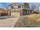 Two-story home featuring brick accents, beige siding, and a spacious two-car garage and driveway at 805 Northridge Rd, Highlands Ranch, CO 80126