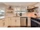 Beautiful updated kitchen with white cabinets, floating shelves, and a stainless steel dishwasher at 805 Northridge Rd, Highlands Ranch, CO 80126
