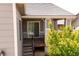 View of a back porch with stone pillars, grey siding, stairs, and a sliding door at 997 Brocade Dr, Highlands Ranch, CO 80126