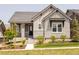 Charming home featuring stone accents, covered porch, tidy landscaping, and a well-maintained front lawn at 997 Brocade Dr, Highlands Ranch, CO 80126