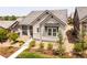 Charming home featuring stone accents, covered porch, tidy landscaping, and a well-maintained front lawn at 997 Brocade Dr, Highlands Ranch, CO 80126