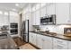 Modern kitchen features stainless steel appliances, white cabinetry with glass uppers, and beautiful tile backsplash at 997 Brocade Dr, Highlands Ranch, CO 80126