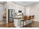 Bright kitchen features white cabinets, stainless steel appliances, and an island with bar stool seating at 997 Brocade Dr, Highlands Ranch, CO 80126