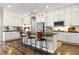 Modern kitchen features white cabinetry, stainless steel appliances, an island with bar stool seating, and hardwood floors at 997 Brocade Dr, Highlands Ranch, CO 80126