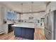 Bright kitchen features a blue center island, stainless steel appliances, and white subway tile backsplash at 2351 Sagebrush St, Parker, CO 80138