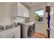 Well-organized laundry room with stainless steel washer and dryer, utility sink, and storage cabinets at 2351 Sagebrush St, Parker, CO 80138