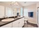 Bathroom with a double sink vanity, large mirror, and a shower with glass doors at 4885 S Algonquian Way, Aurora, CO 80016