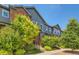 Inviting townhome with brick and gray siding, complemented by lush greenery and a well-kept lawn at 4885 S Algonquian Way, Aurora, CO 80016