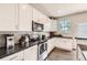 Well-appointed kitchen with white cabinets, stainless steel appliances, and ample counter space at 4885 S Algonquian Way, Aurora, CO 80016