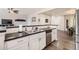 Open kitchen featuring white cabinets, stainless steel appliances, and a breakfast bar overlooking the living area at 4885 S Algonquian Way, Aurora, CO 80016