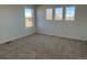 Cozy bedroom with neutral carpet and three windows offering lots of natural light at 2025 Barnwood Dr, Brighton, CO 80601