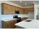 Bright kitchen featuring wooden cabinets, white countertops, stainless steel appliances, and a center island at 2025 Barnwood Dr, Brighton, CO 80601