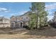 Scenic townhome exterior featuring natural landscaping, mature trees, and neutral paint at 9771 Mayfair St # F, Englewood, CO 80112
