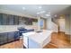 Well-lit kitchen boasts a large island, dark cabinets, modern appliances, and hardwood floors at 23970 E 41St Ave, Aurora, CO 80019