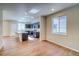 Bright open space with hardwood floors, recessed lights, and a view into the well-lit modern kitchen at 23970 E 41St Ave, Aurora, CO 80019