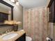 Bathroom featuring a granite vanity top, decorative mirror, and shower with patterned curtain at 8240 Clayton Ct, Denver, CO 80229