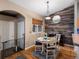 Charming dining area with wood floors, stylish chandelier, and views to the front entrance at 8240 Clayton Ct, Denver, CO 80229