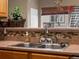 This kitchen features a stainless steel sink, mosaic backsplash and a lovely basketed plant at 8240 Clayton Ct, Denver, CO 80229