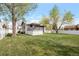 Lush backyard featuring a spacious lawn and back deck at 2055 Quail Dr, Lakewood, CO 80215