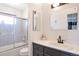 Bright bathroom featuring a shower-tub combination, vanity, and decorative mirrors at 2055 Quail Dr, Lakewood, CO 80215