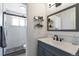 Modern bathroom featuring a tiled shower, vanity with dark wood cabinets, and a sleek mirror at 2055 Quail Dr, Lakewood, CO 80215