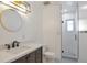 Stylish bathroom with a modern vanity, round mirror, and glass-enclosed shower at 2055 Quail Dr, Lakewood, CO 80215