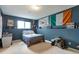 Bedroom featuring blue walls, window, and various wall decorations at 2055 Quail Dr, Lakewood, CO 80215