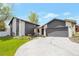 Inviting home exterior with a wide driveway, complemented by lush green lawn and tasteful landscaping at 2055 Quail Dr, Lakewood, CO 80215